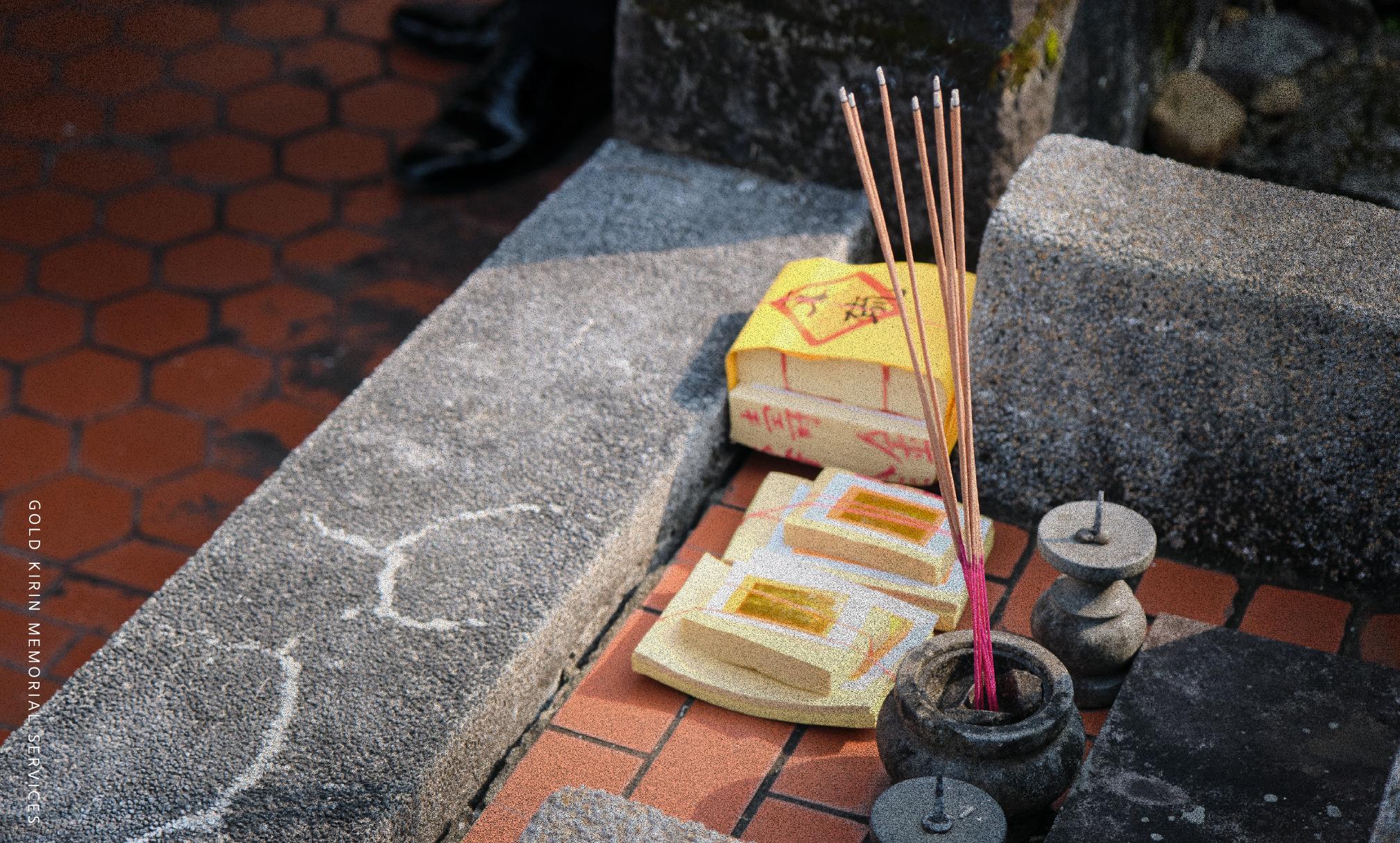 傳統墓園前點燃的線香與祭祖必備的金紙疊放特寫
